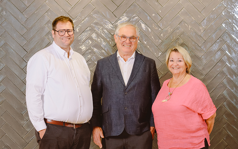 Domink, Siegfried und Petra Beck stehend vor einer Wand